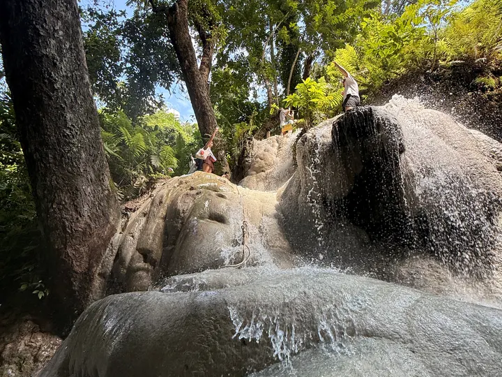 People using a fixed rope on a steep, fast-flowing face.