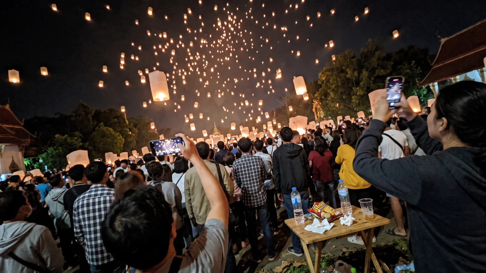Paper lanterns rising into the night sky over Chiang Mai during Yi Peng